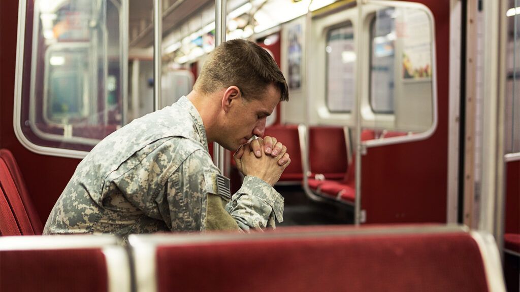 A solider, alone with his thoughts, on a train