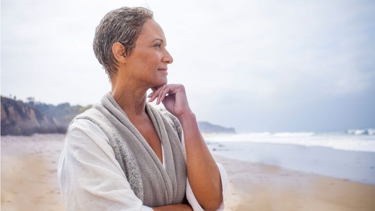 A serene woman gazes out at the ocean