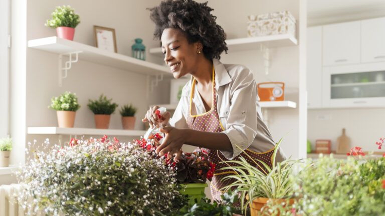 Woman looking over her plants while doing a spiritual spring cleaning