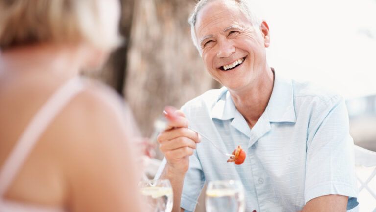 A senior man enjoying lunch outdoors; Getty Images