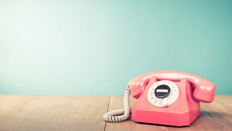 A pink vintage rotary phone; Getty Images