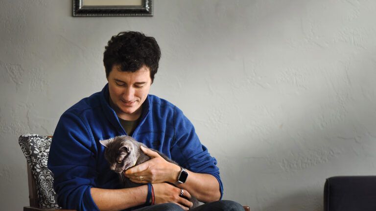 Josh Marino holding his pet cat; Photo credit: Scott Goldsmith