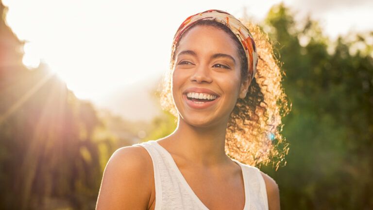 Woman smiling during a sunset.
