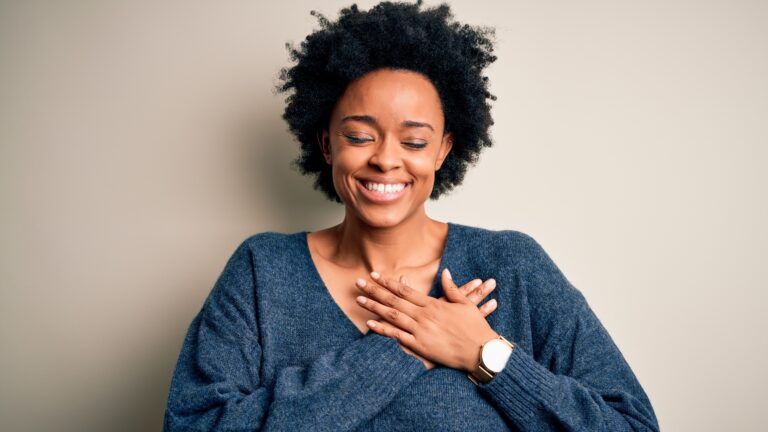 Woman with her hands on her heart proud of herself for doing her new habits